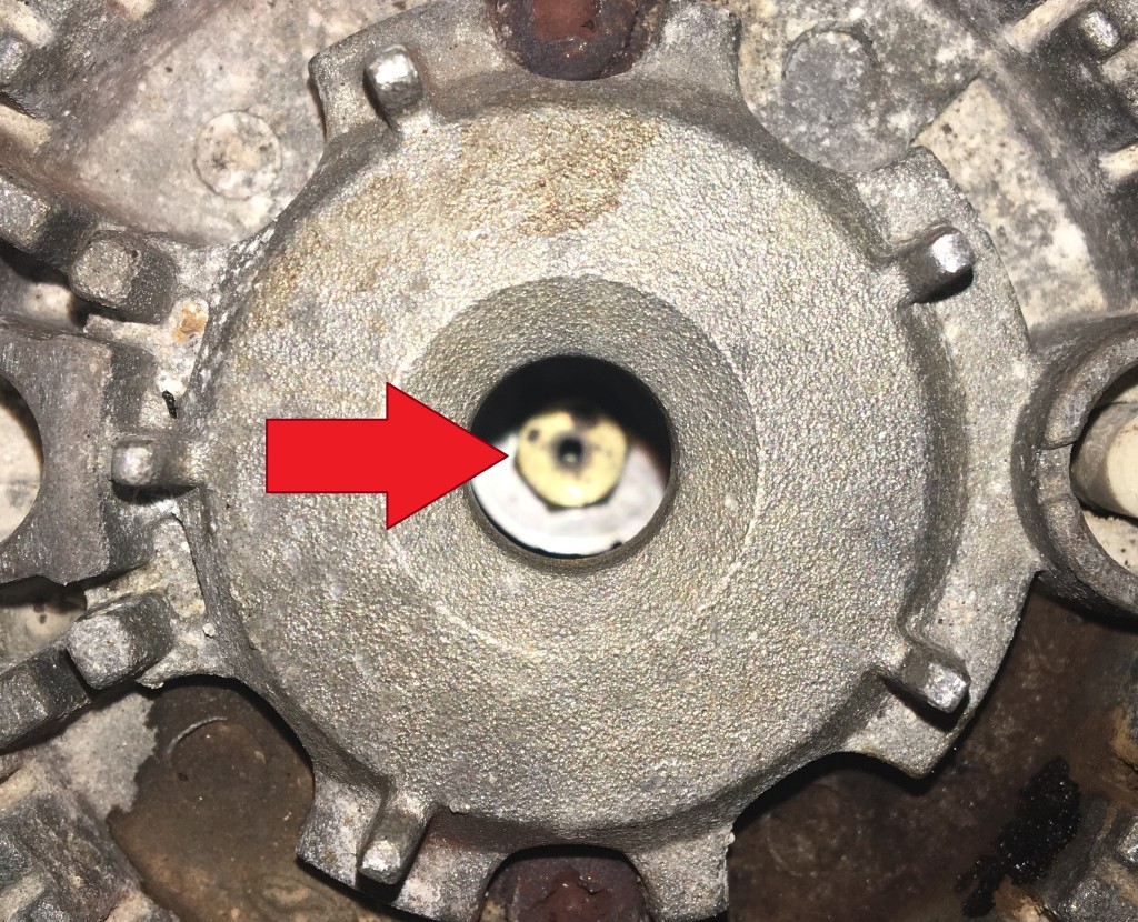 The small brass orifice in the center of the burner is what needs to be cleaned.